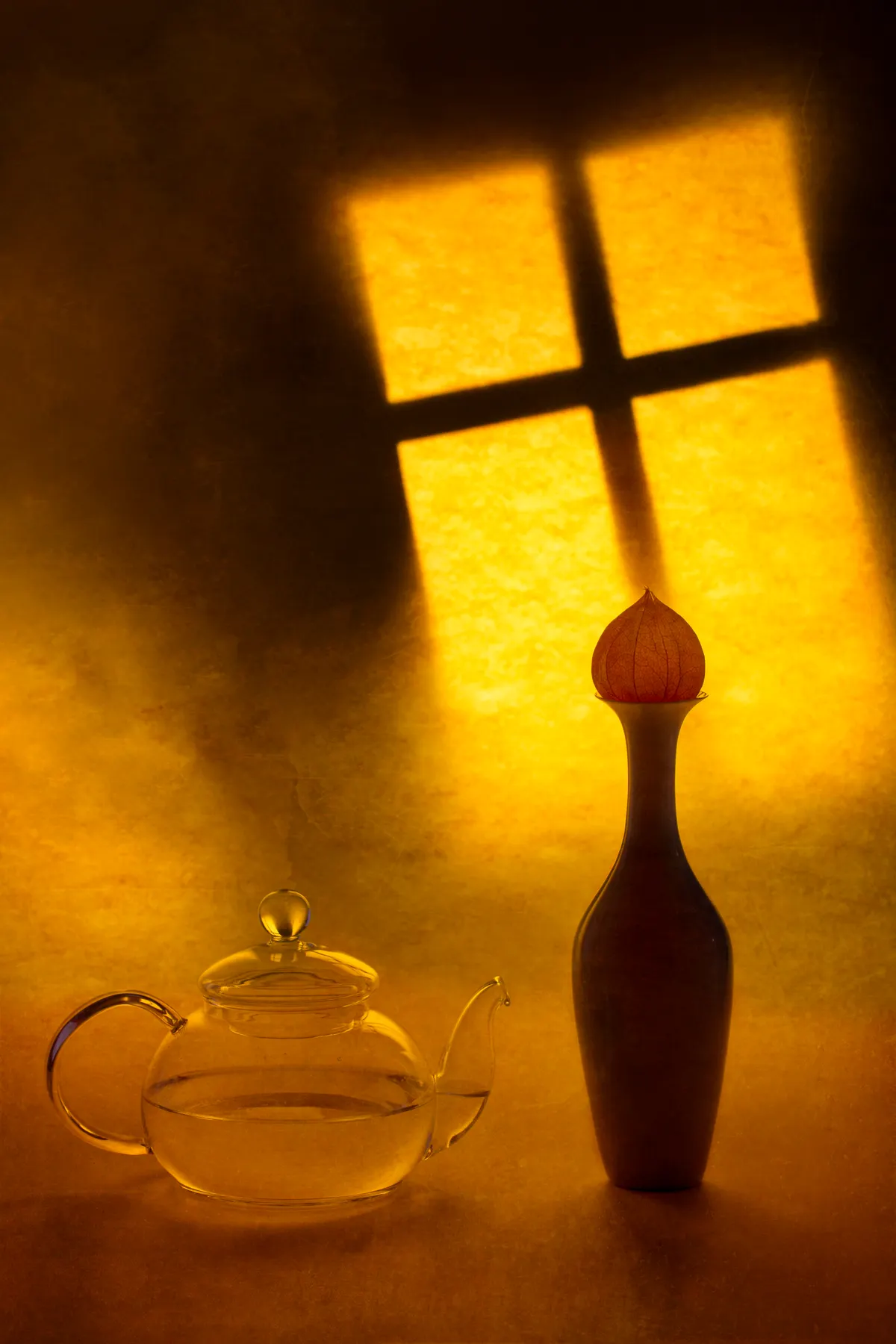 Glass teapot and sculptural vase in a sunlit editorial still life