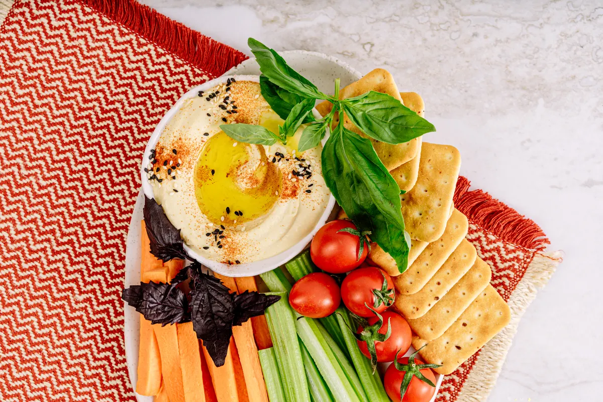Fresh hummus platter with vegetables in a colorful top-down layout