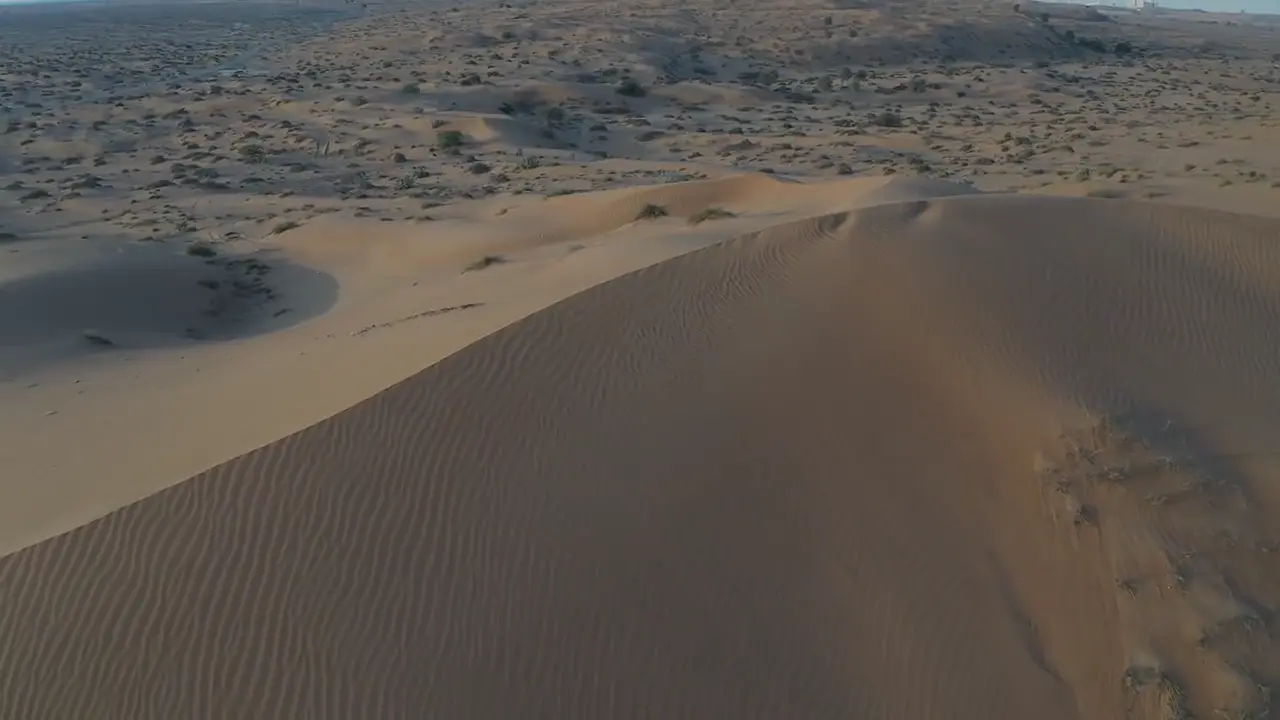 Aerial glide over flowing golden desert dunes