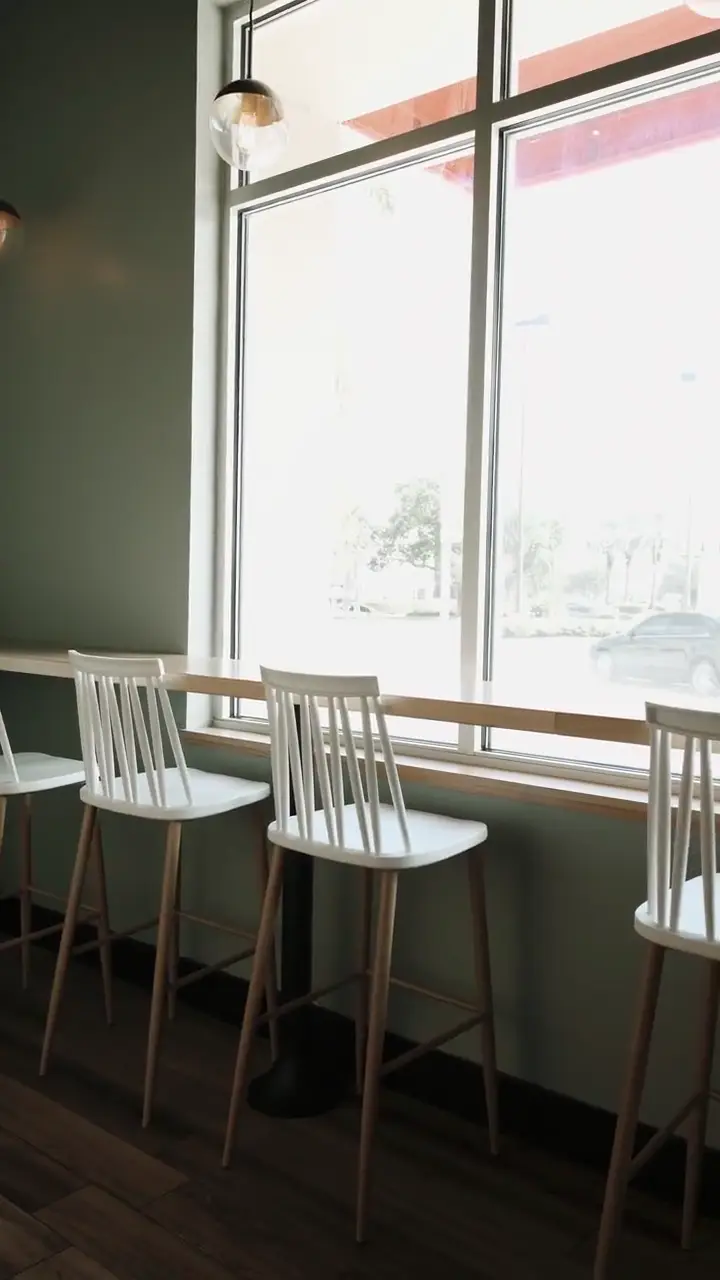 Sunlit vertical tour through a calm modern cafe interior